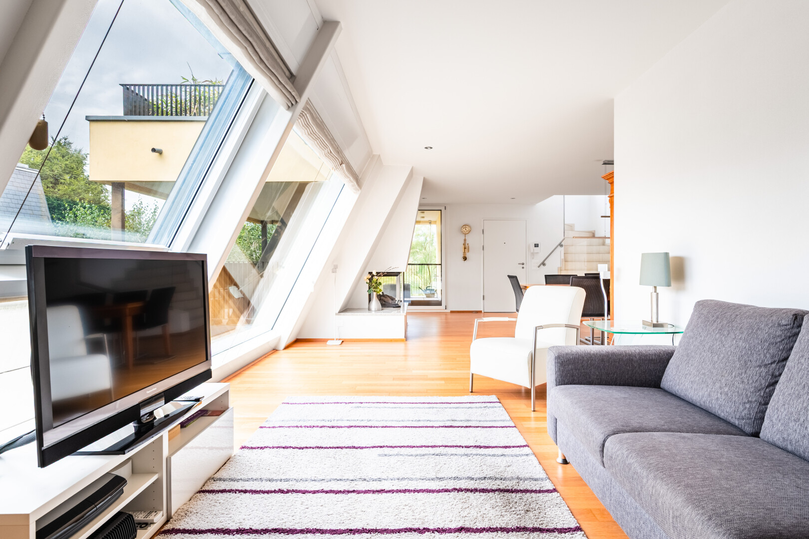 salon avec inside property, natural light, lumière naturelle, wood finish floor, et sol en finition bois