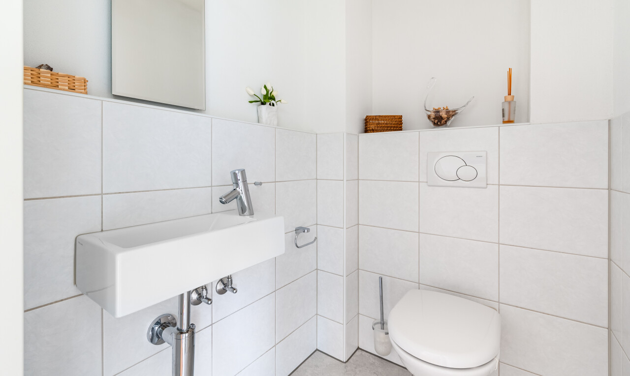 salle de bains avec tile wall, mur en carrelage, toilette, inside property, et miroir