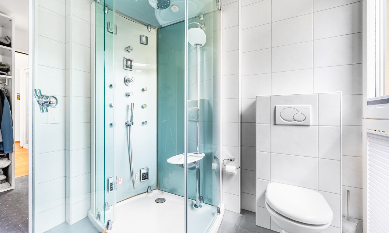 salle de bains avec salle de bain complète, douche, mur en carrelage, tile wall, et toilette