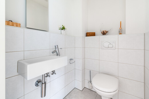 salle de bains avec tile wall, mur en carrelage, toilette, inside property, et miroir
