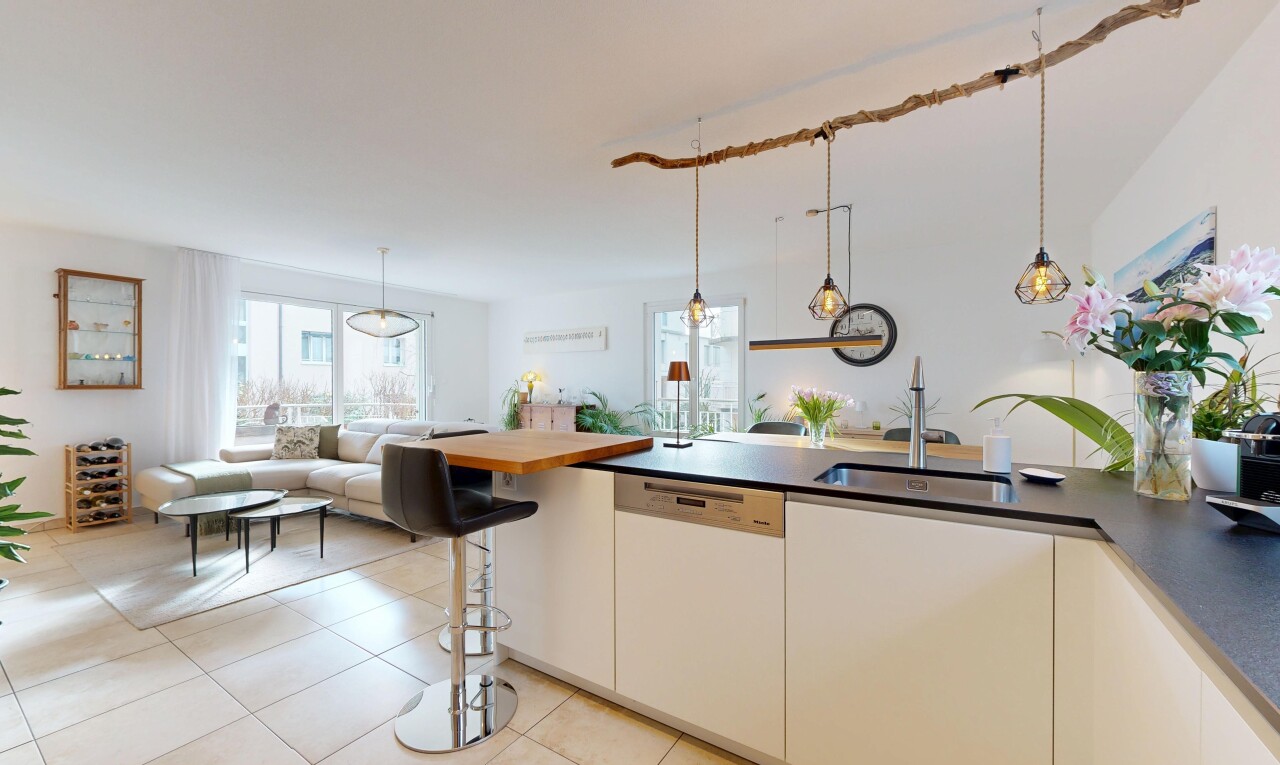 cuisine avec dark countertops, éclairage suspendu, pendant lighting, lave-vaisselle, et ouvert sur l'espace de vie