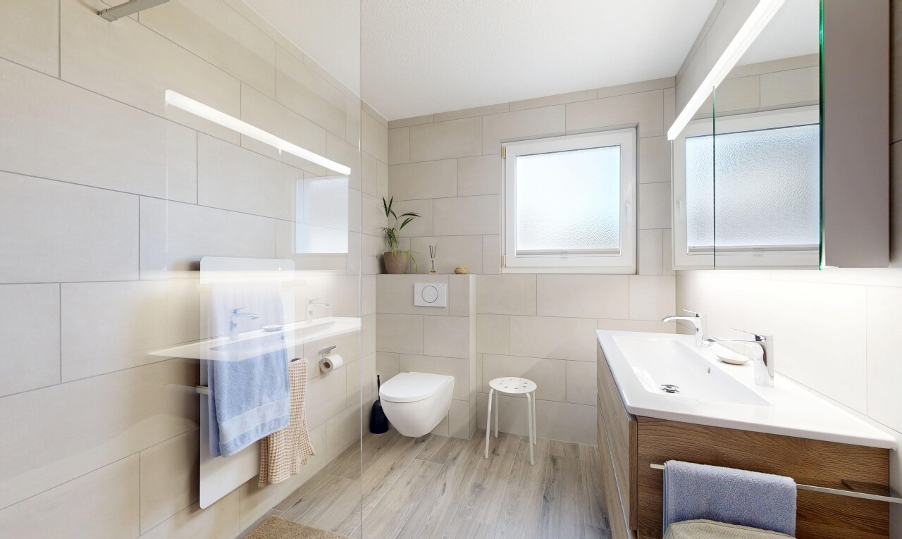 salle de bains avec miroir, lavabo (ou coiffeuse selon le contexte), tile wall, mur en carrelage, et natural light