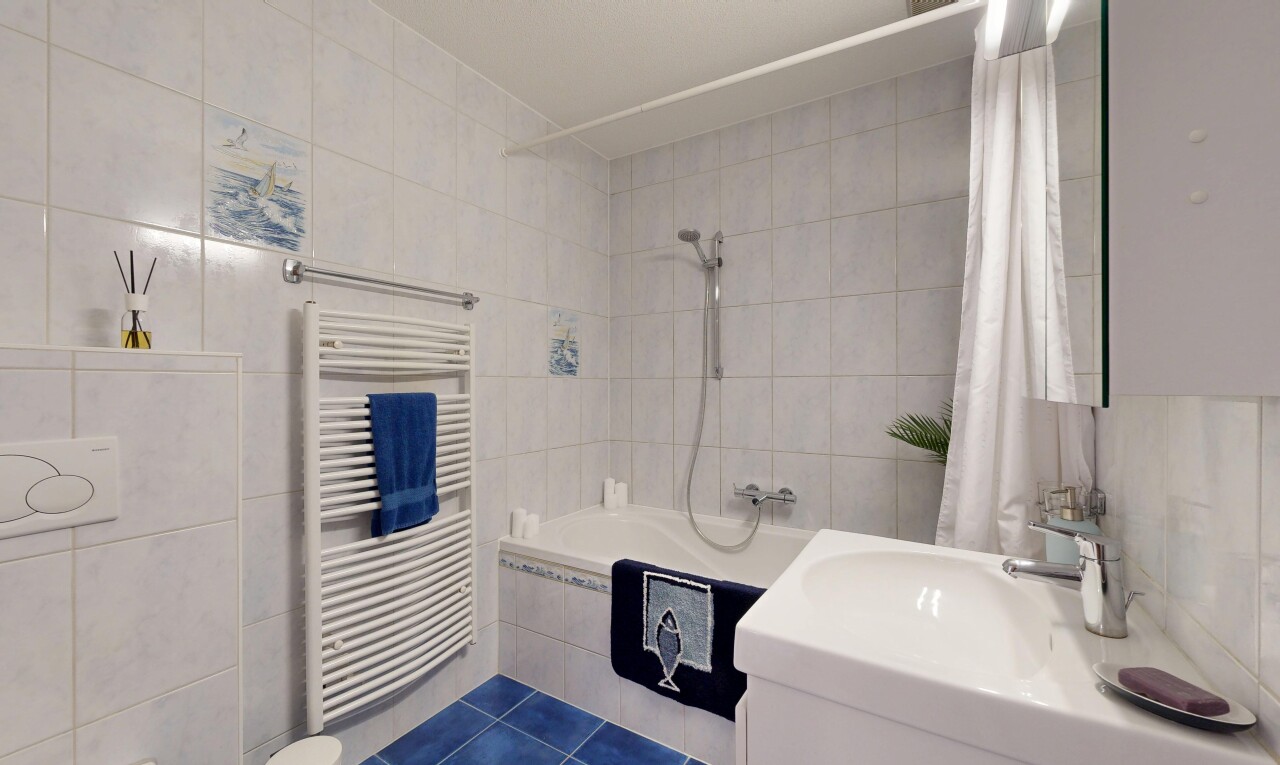 salle de bains avec mur en carrelage, tile wall, dark floor, douche-bain combinés, et salle de bain complète