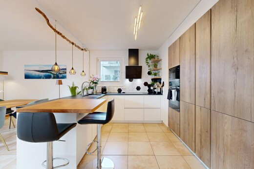 cuisine avec bar de cuisine, kitchen bar, éclairage suspendu, pendant lighting, et péninsule de cuisine