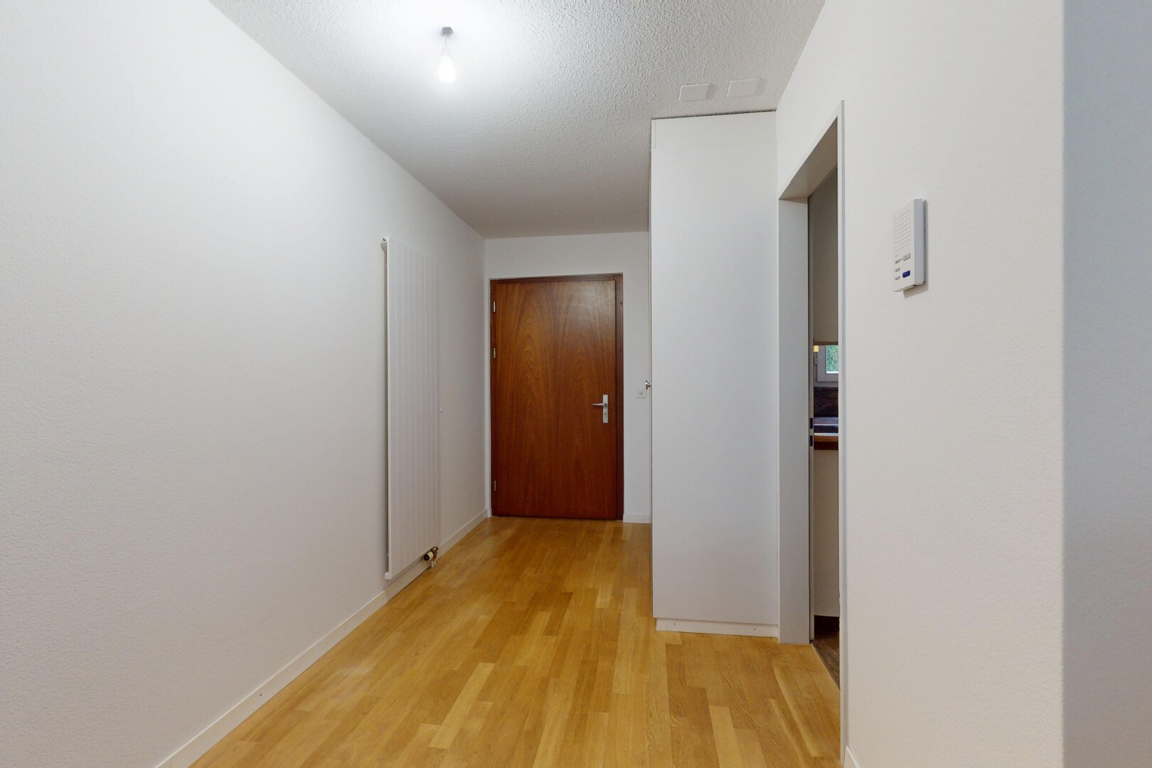 halle / korridor mit holzfußboden, wood finish floor, inside property, spritzputz decke, und textured ceiling