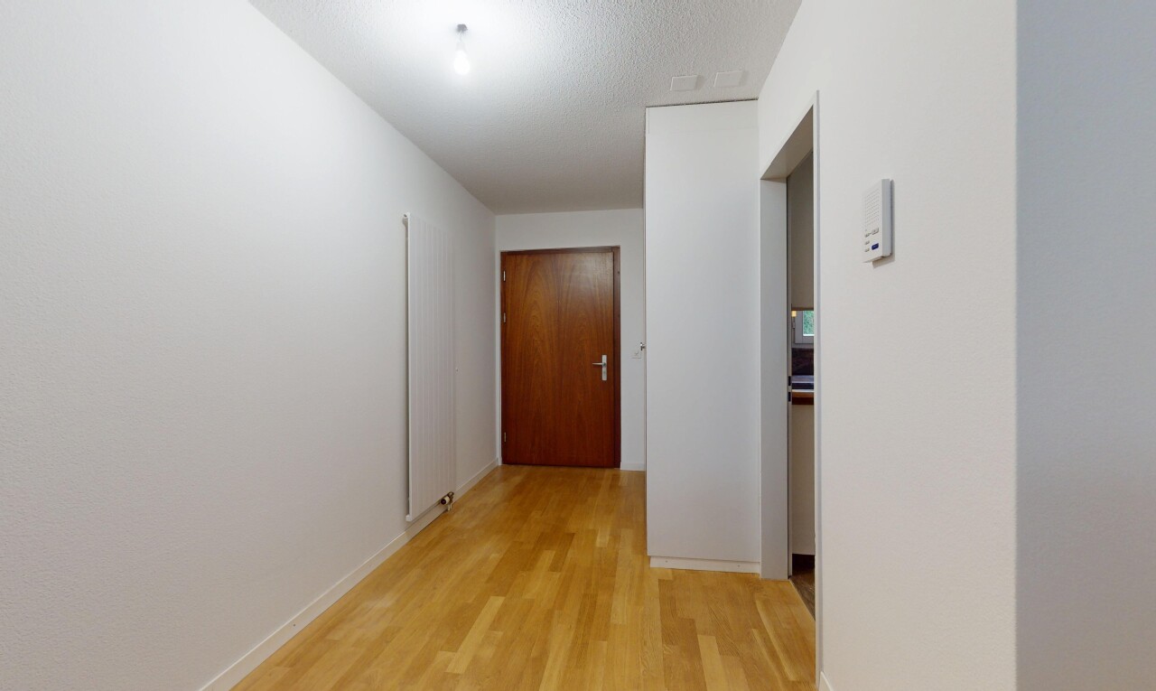 halle / korridor mit holzfußboden, wood finish floor, inside property, spritzputz decke, und textured ceiling