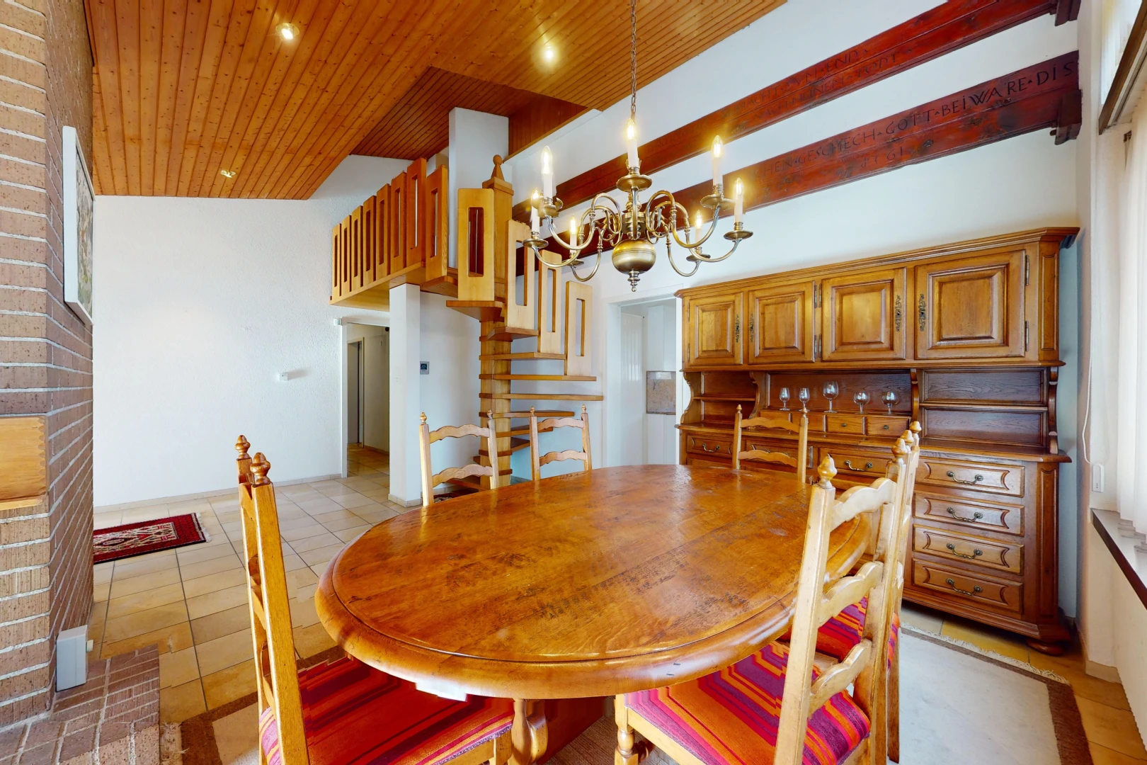 salle à manger avec haut plafond, plafond de bois, lustre, et carrelage