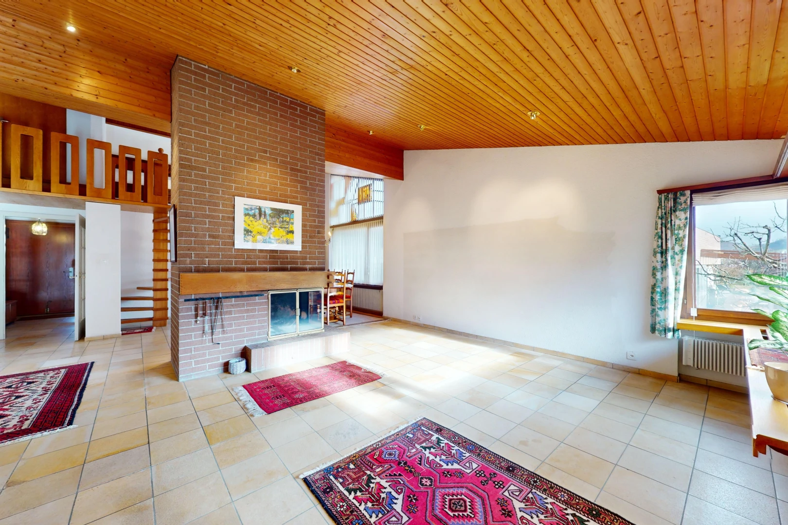 salon avec radiateur, lumière naturelle, carrelage, plafond voûté, et plafond de bois