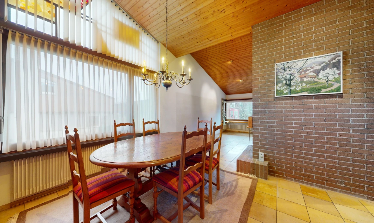 salle à manger avec lumière naturelle, lustre, mur en briques, carrelage, et plafond de bois