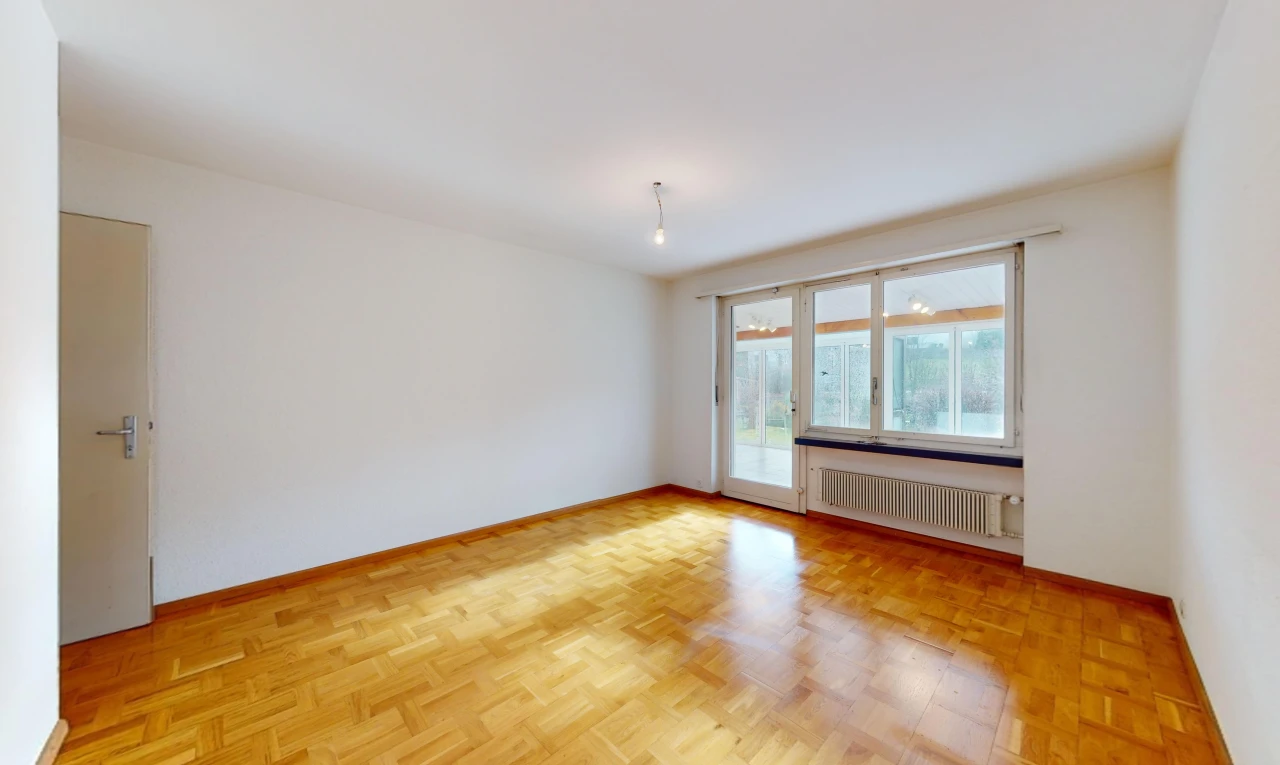 pièce vide avec radiateur, parquet, et lumière naturelle