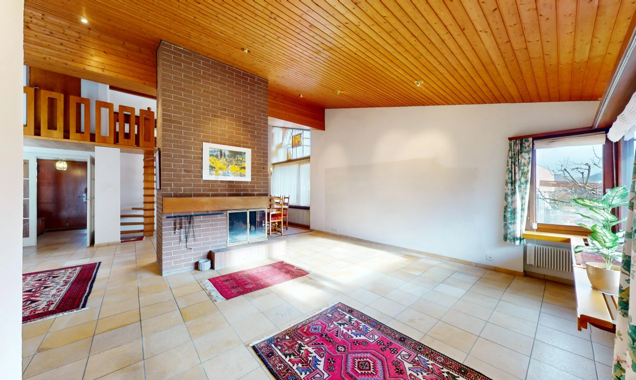 salon avec radiateur, lumière naturelle, carrelage, plafond voûté, et plafond de bois