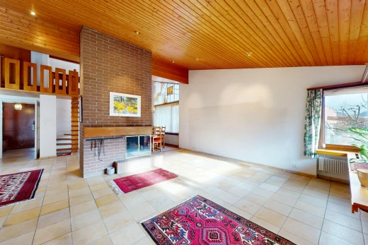 salon avec radiateur, lumière naturelle, carrelage, plafond voûté, et plafond de bois