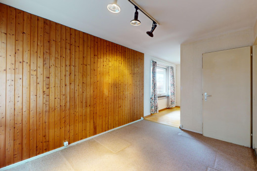 pièce vide avec lumière naturelle, éclairage sur rail, moquette, et mur en bois