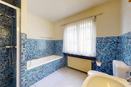 salle de bains avec lumière naturelle, carrelage, mur carrelé, et radiateur