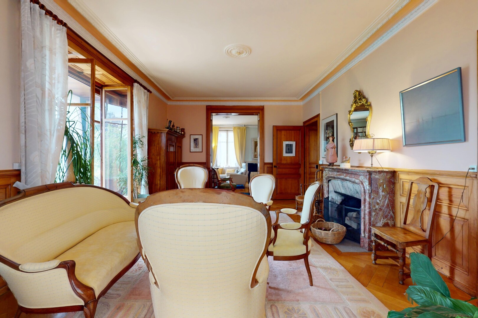 salon avec télévision, lumière naturelle, natural light, inside property, et moulures