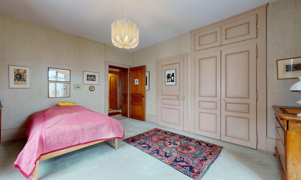 chambre avec moquette, carpet, lustre remarquable, inside property, et mur en papier peint