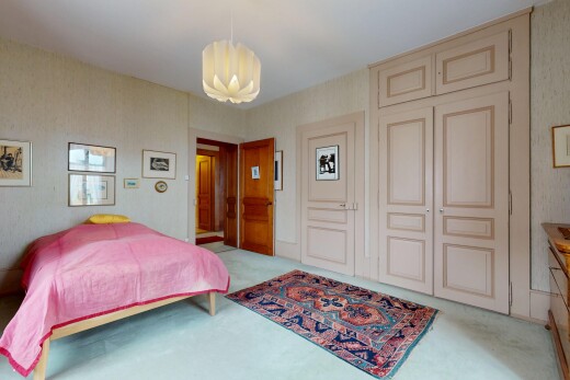 chambre avec moquette, carpet, lustre remarquable, inside property, et mur en papier peint