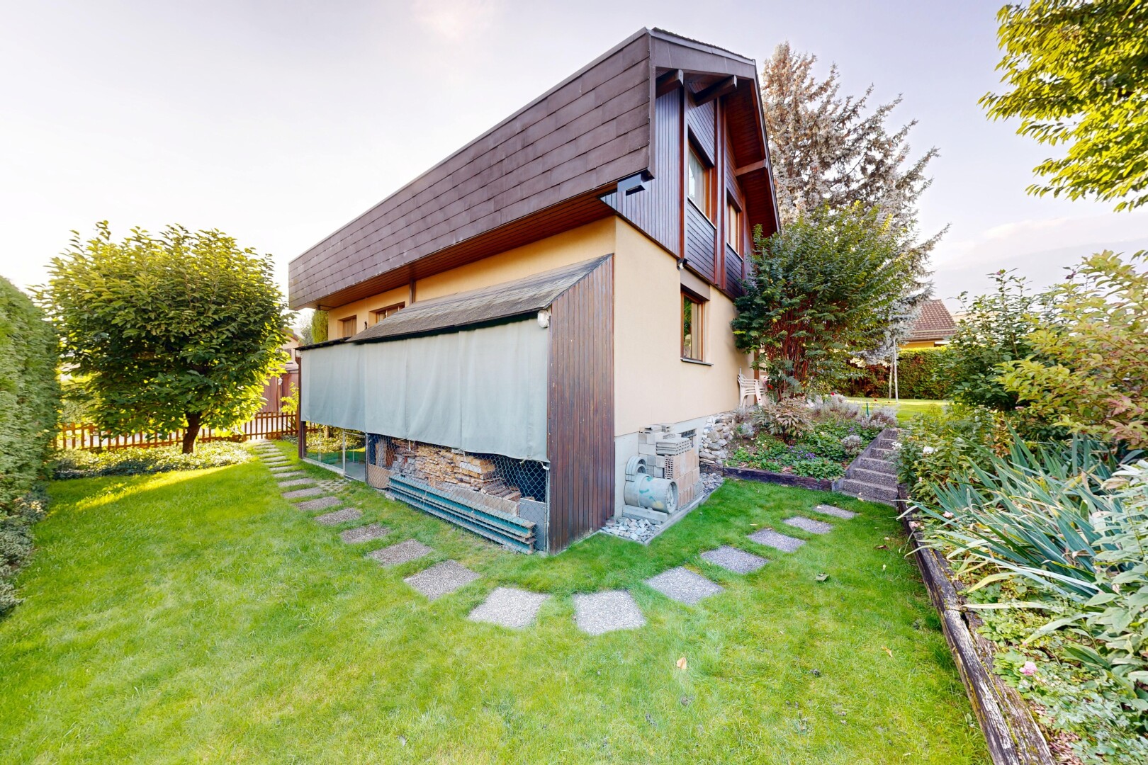 façade avec bardage vertical, pelouse, property visible, et clôture