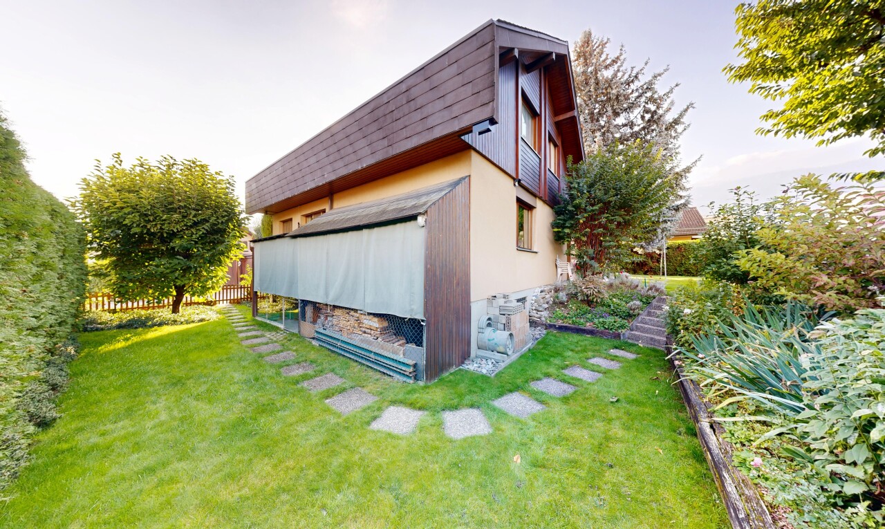 façade avec bardage vertical, pelouse, property visible, et clôture