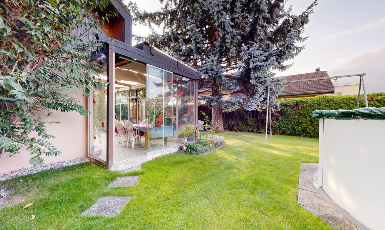 jardin avec pelouse, véranda, clôture, et terrasse