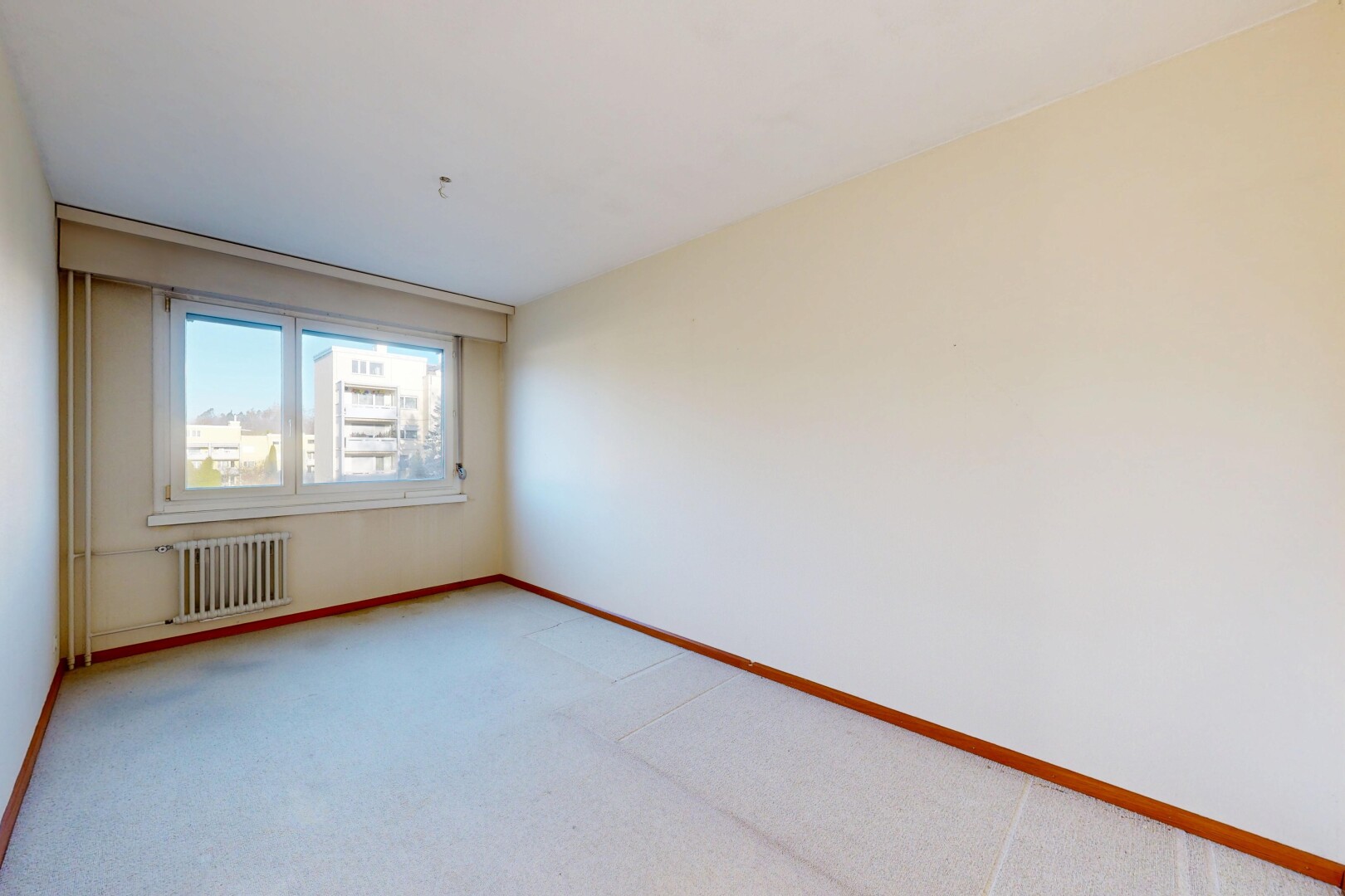 pièce vide avec moquette, carpet, cloison sèche, drywall, et radiateur