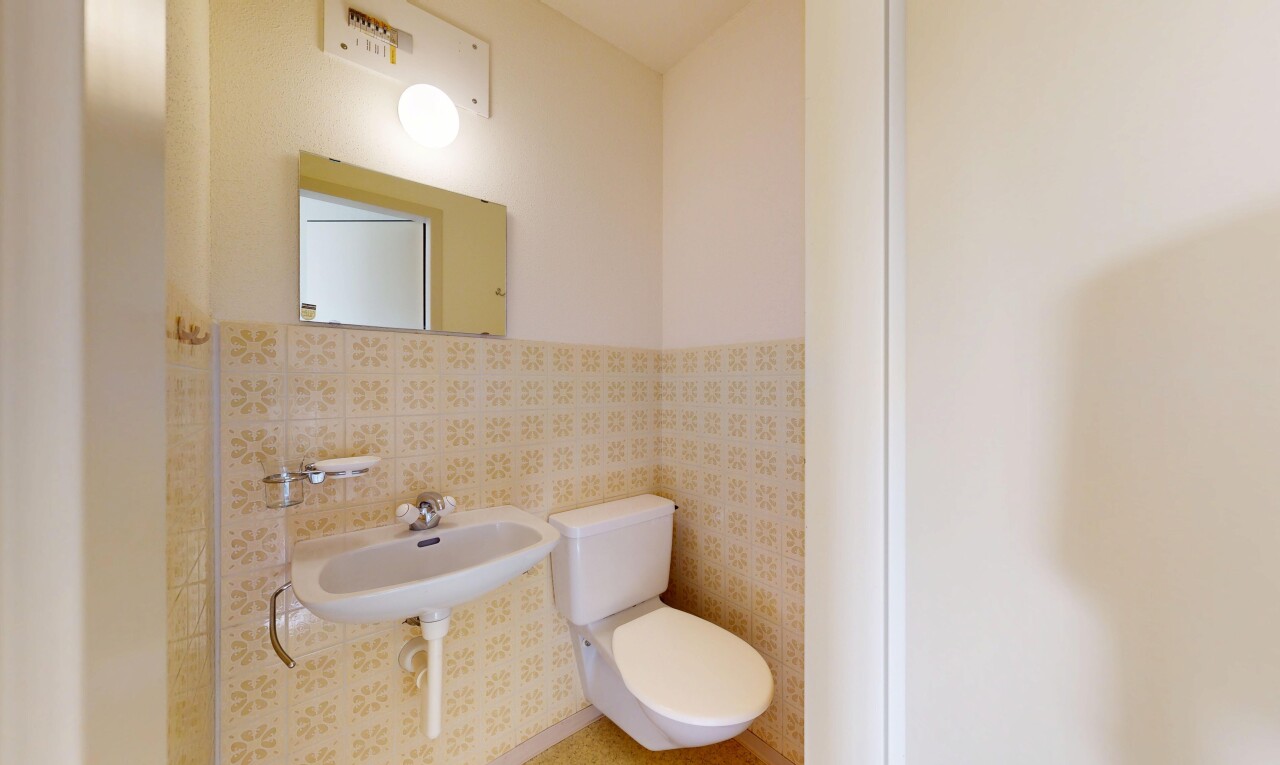salle de bains avec miroir, toilette, inside property, évier, et cloison sèche
