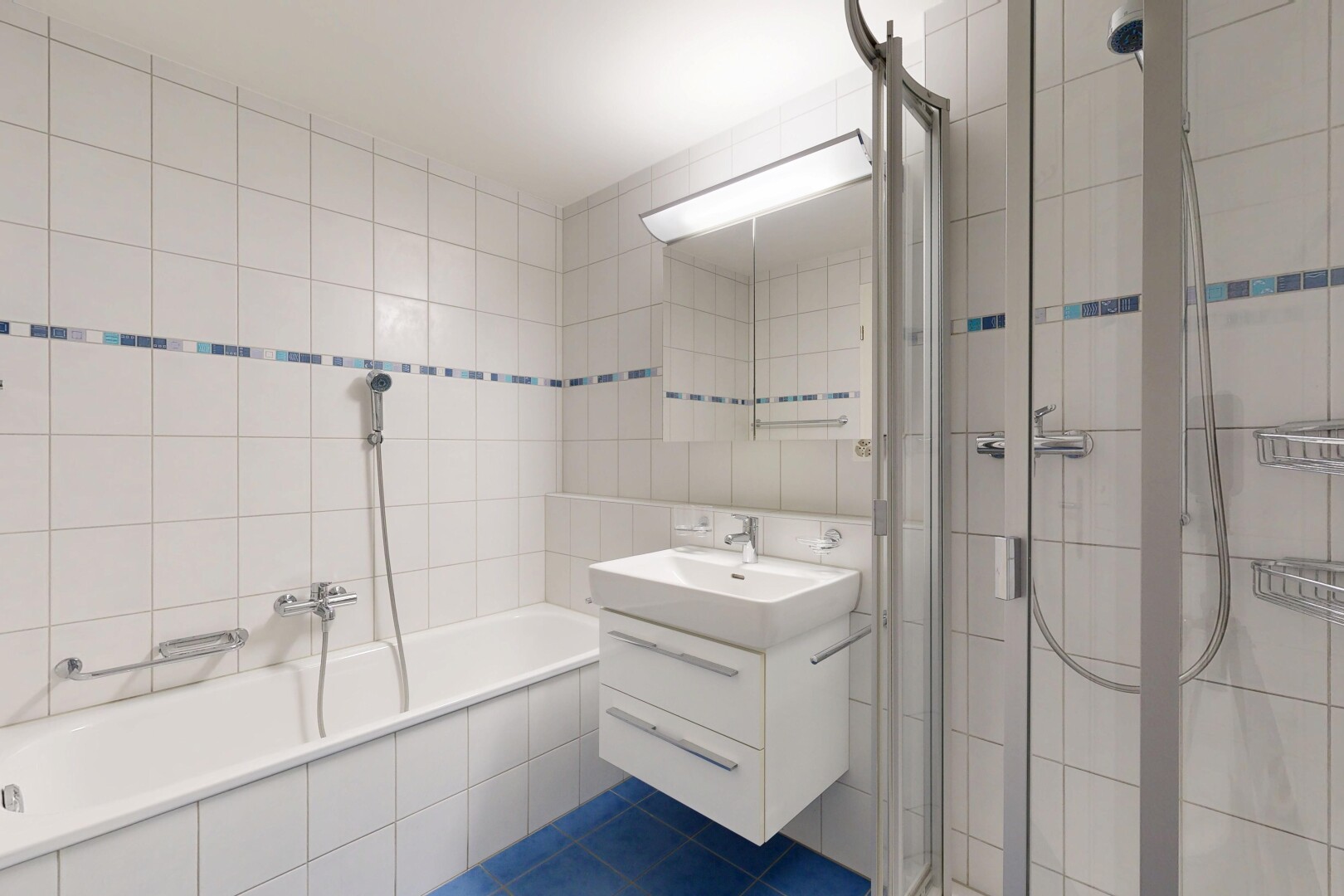bathroom featuring a shower stall, tile walls, vanity, tile patterned flooring, and tiled bath