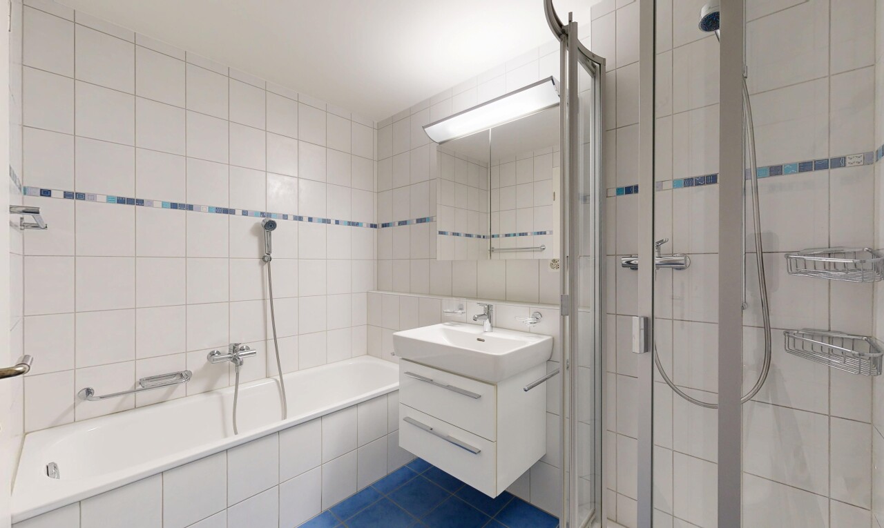 bathroom featuring a shower stall, tile walls, vanity, tile patterned flooring, and tiled bath