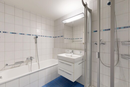 bathroom featuring a shower stall, tile walls, vanity, tile patterned flooring, and tiled bath