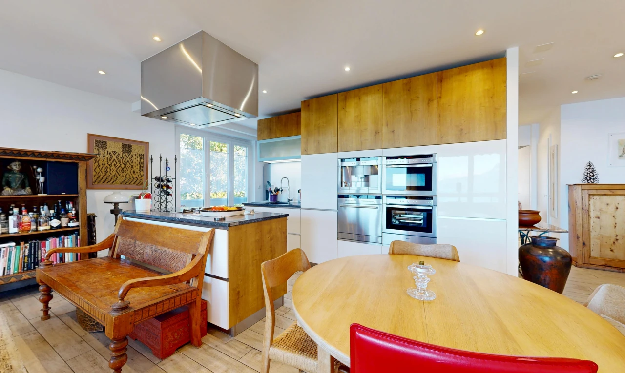 cuisine avec armoires marron moyen, medium brown cabinets, dark countertops, éclairage encastré, et light floor