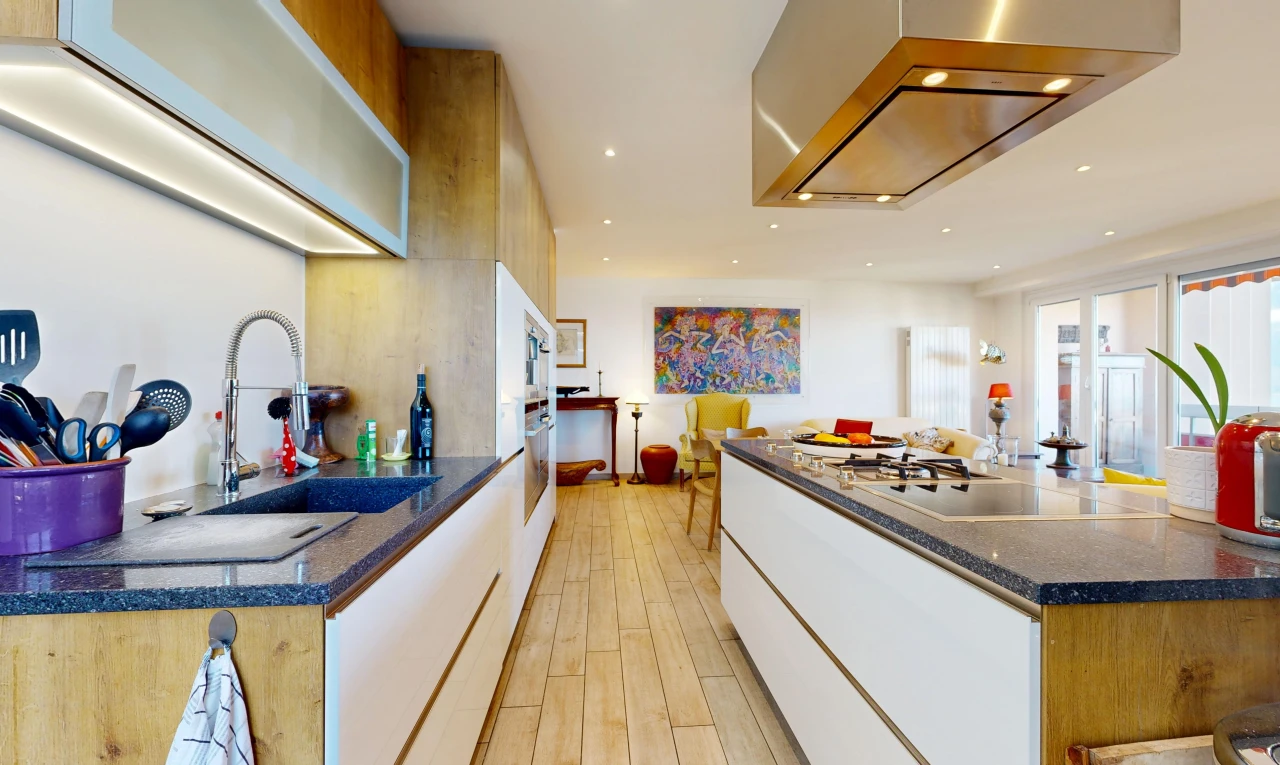 cuisine avec hotte, dark countertops, light floor, évier, et éclairage encastré