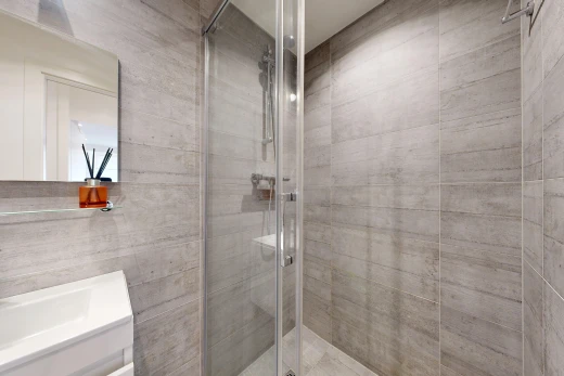 salle de bains avec miroir, douche, salle de bain complète, lavabo (ou coiffeuse selon le contexte), et inside property