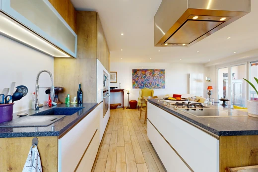 cuisine avec hotte, dark countertops, light floor, évier, et éclairage encastré
