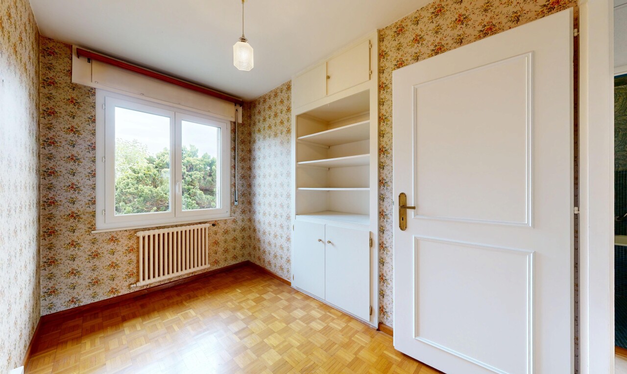 unfurnished room with parquet floors, radiator, and wallpapered walls