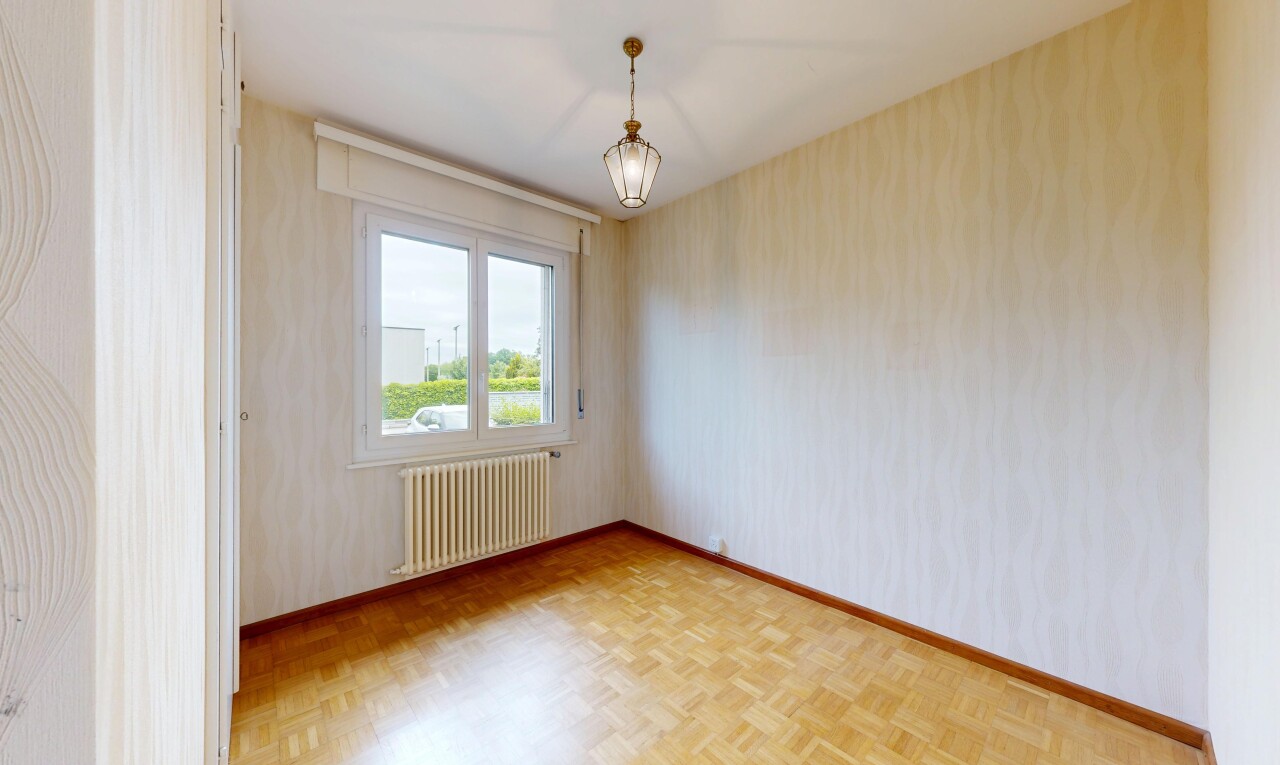 empty room featuring radiator heating unit, parquet flooring, and wallpapered walls