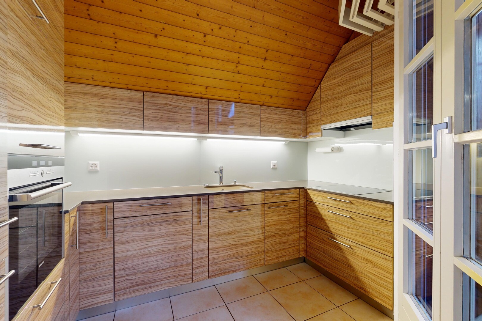 küche mit inside property, ofen, schränke mit flachen paneelen, fliesenboden, und tile floor
