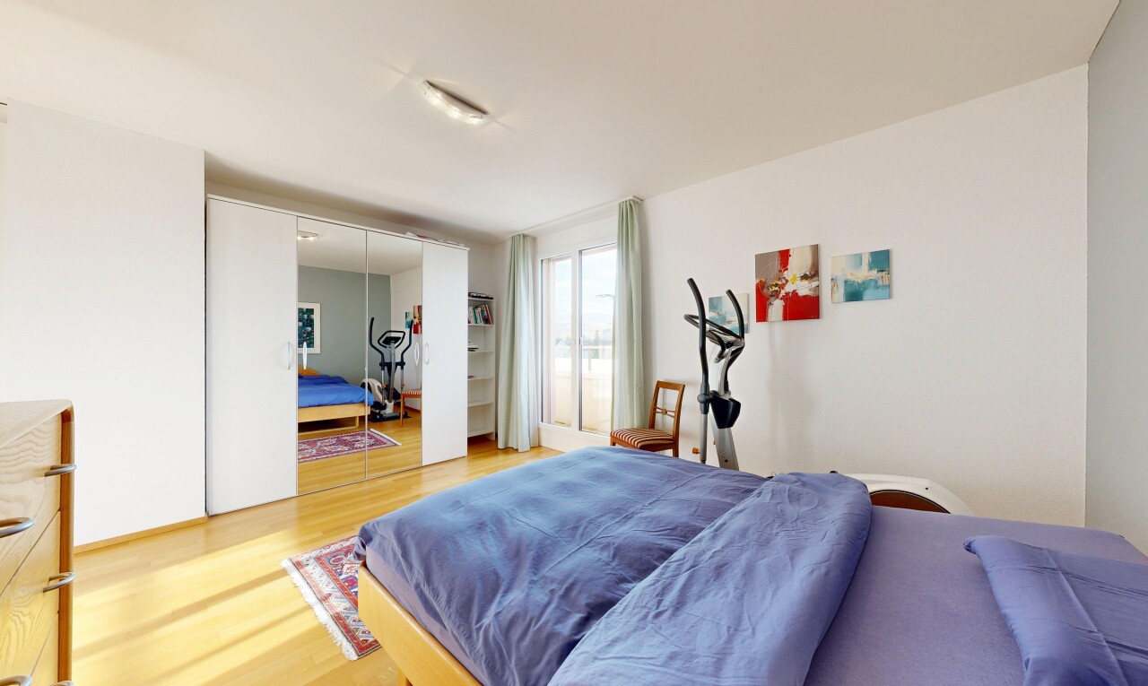 chambre avec wood finish floor, sol en finition bois, drywall, cloison sèche, et natural light