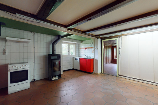 cuisine avec poutres apparentes, carrelage, lumière naturelle, four intégré, lave-vaisselle, et sol clair