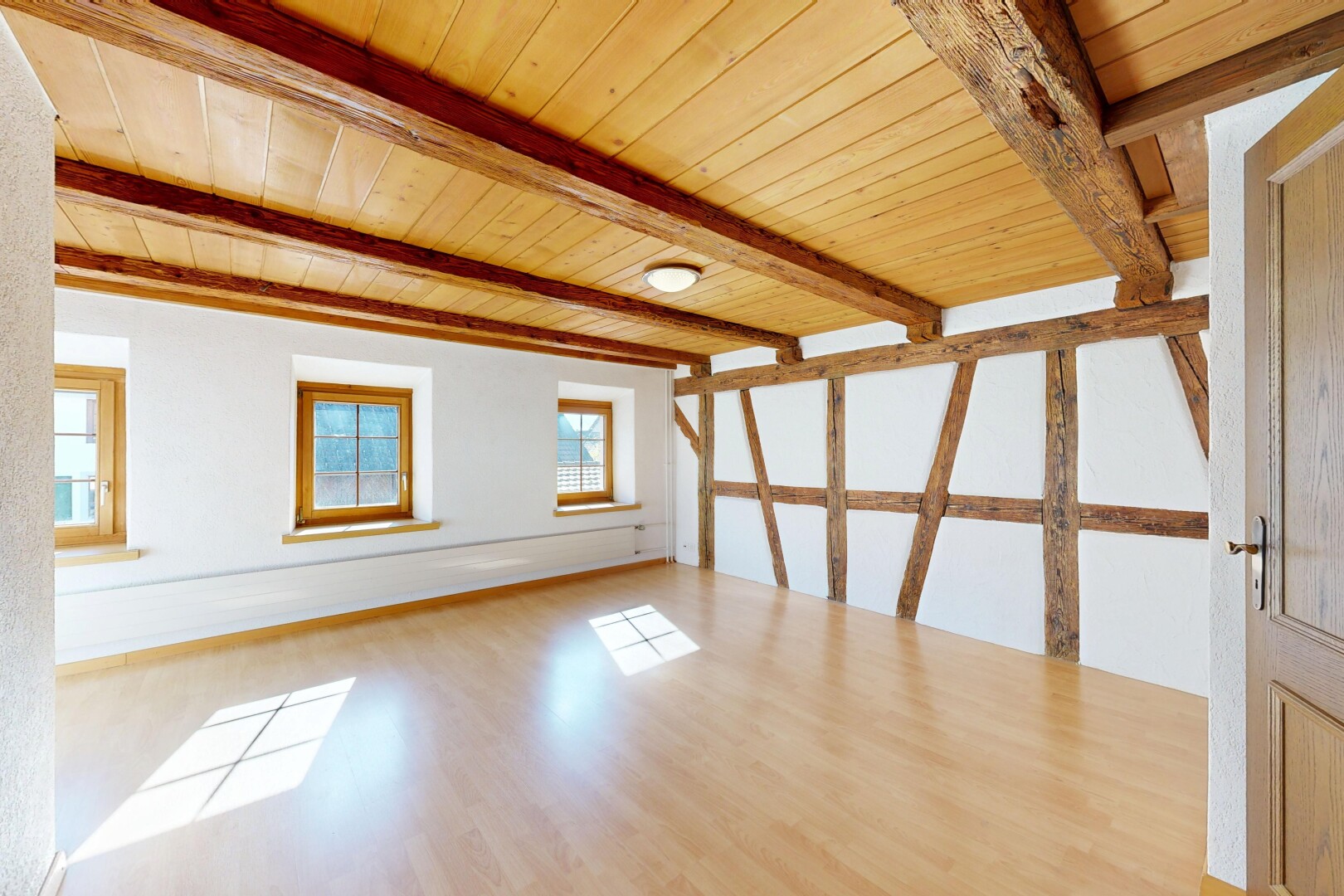 pièce vide avec plafond à poutres, beamed ceiling, sol en finition bois, wood finish floor, et inside property