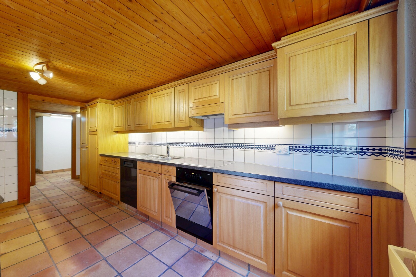 cuisine avec armoires élevées, inside property, sol en carrelage, tile floor, et dosseret