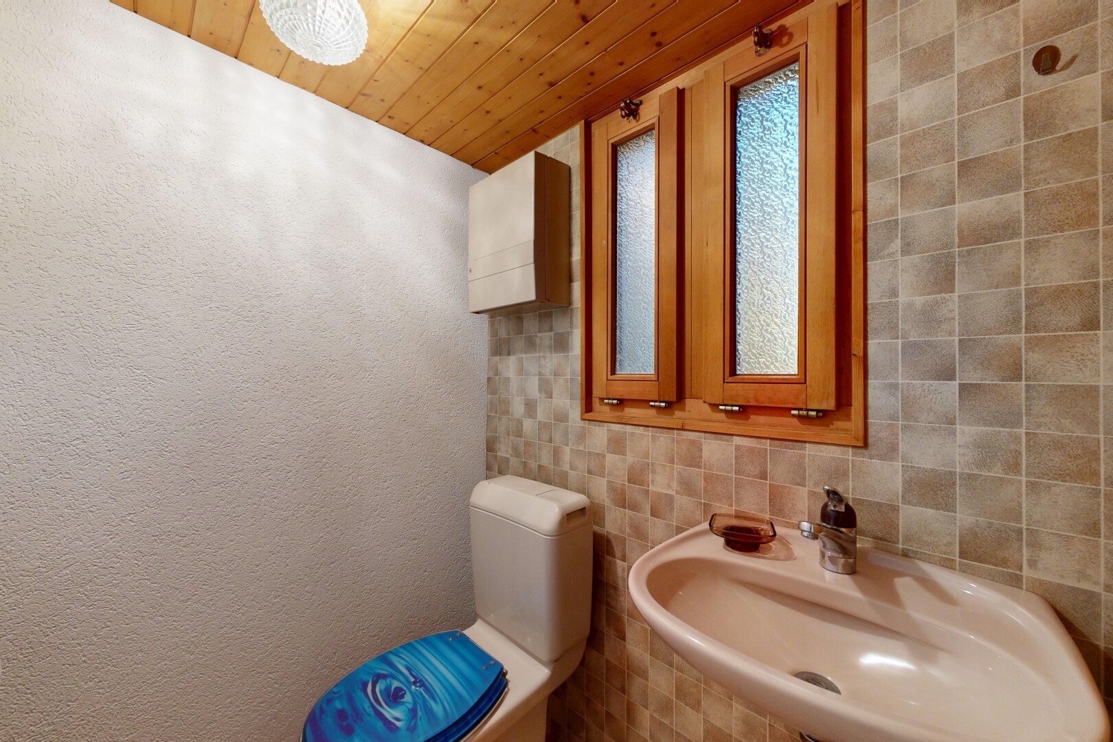 salle de bains avec évier, miroir, wood ceiling, plafond en bois, et inside property