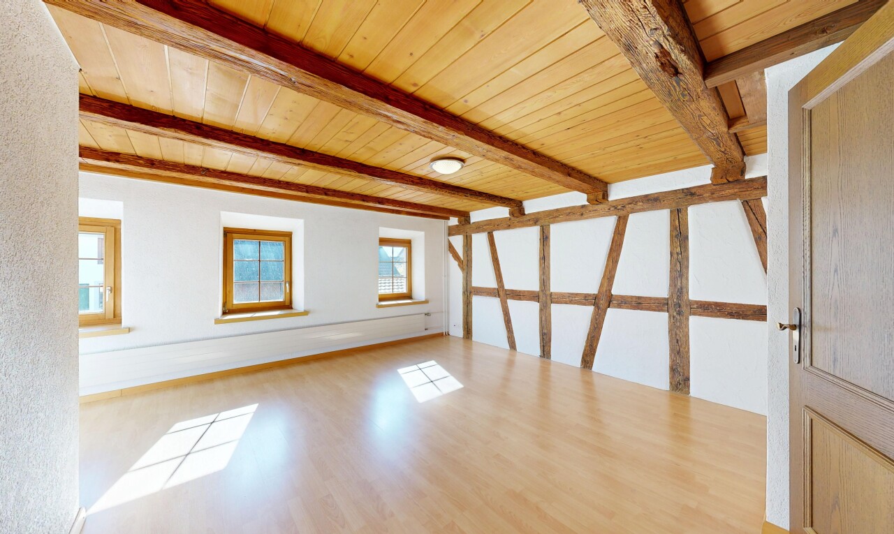 pièce vide avec plafond à poutres, beamed ceiling, sol en finition bois, wood finish floor, et inside property