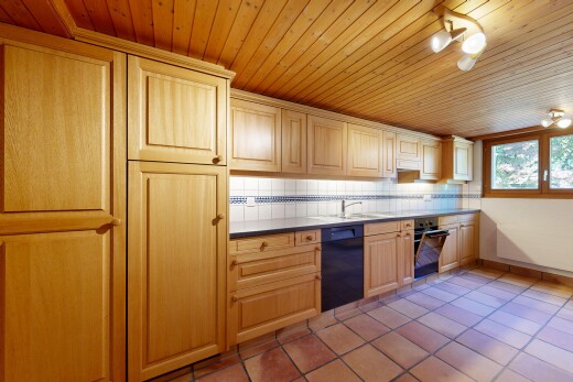küche mit tile floor, fliesenboden, hochgezogene schränke, schränke mit zierleisten, und küchenrückwand beim Herd