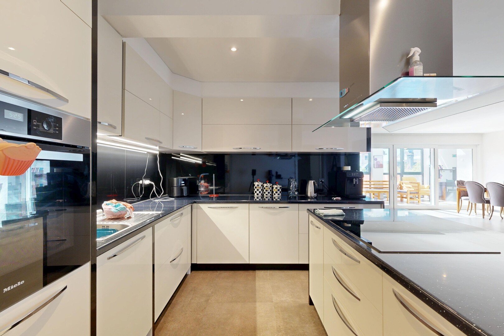 cuisine avec hotte, dark countertops, four, inside property, et armoires à panneau plat