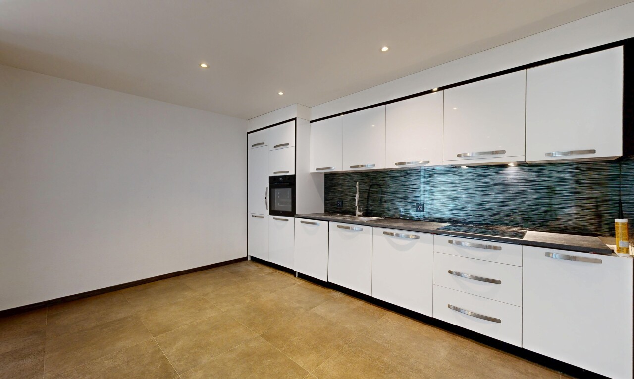 cuisine avec dark countertops, dosseret, backsplash, armoires blanches, et white cabinets