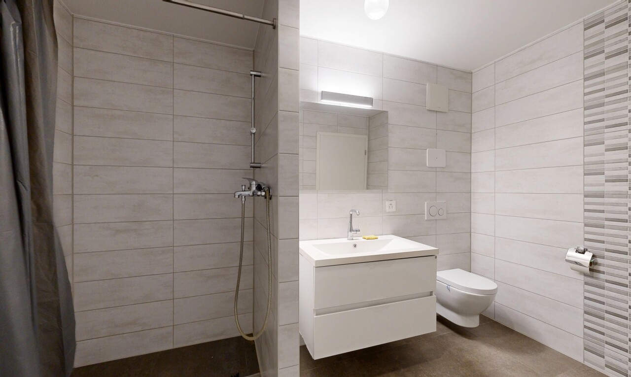 salle de bains avec salle de bain complète, douche, mur en carrelage, tile wall, et miroir