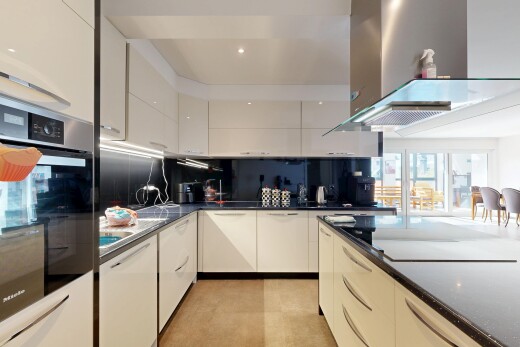 küche mit dunstabzugshaube, dark countertops, ofen, inside property, und schränke mit flachen paneelen