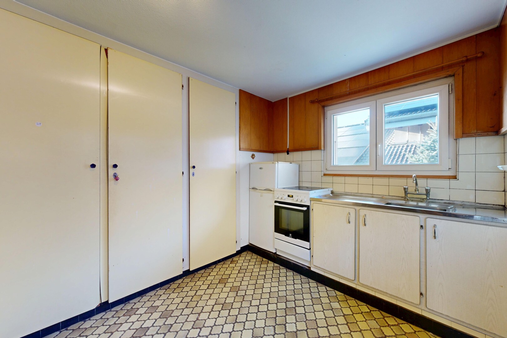 cuisine avec sol en vinyle, vinyl floor, vinyl tile, cuisinière, et armoires à charnières visibles