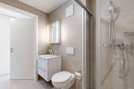 bathroom with a stall shower, vanity, tile walls, and light tile patterned floors