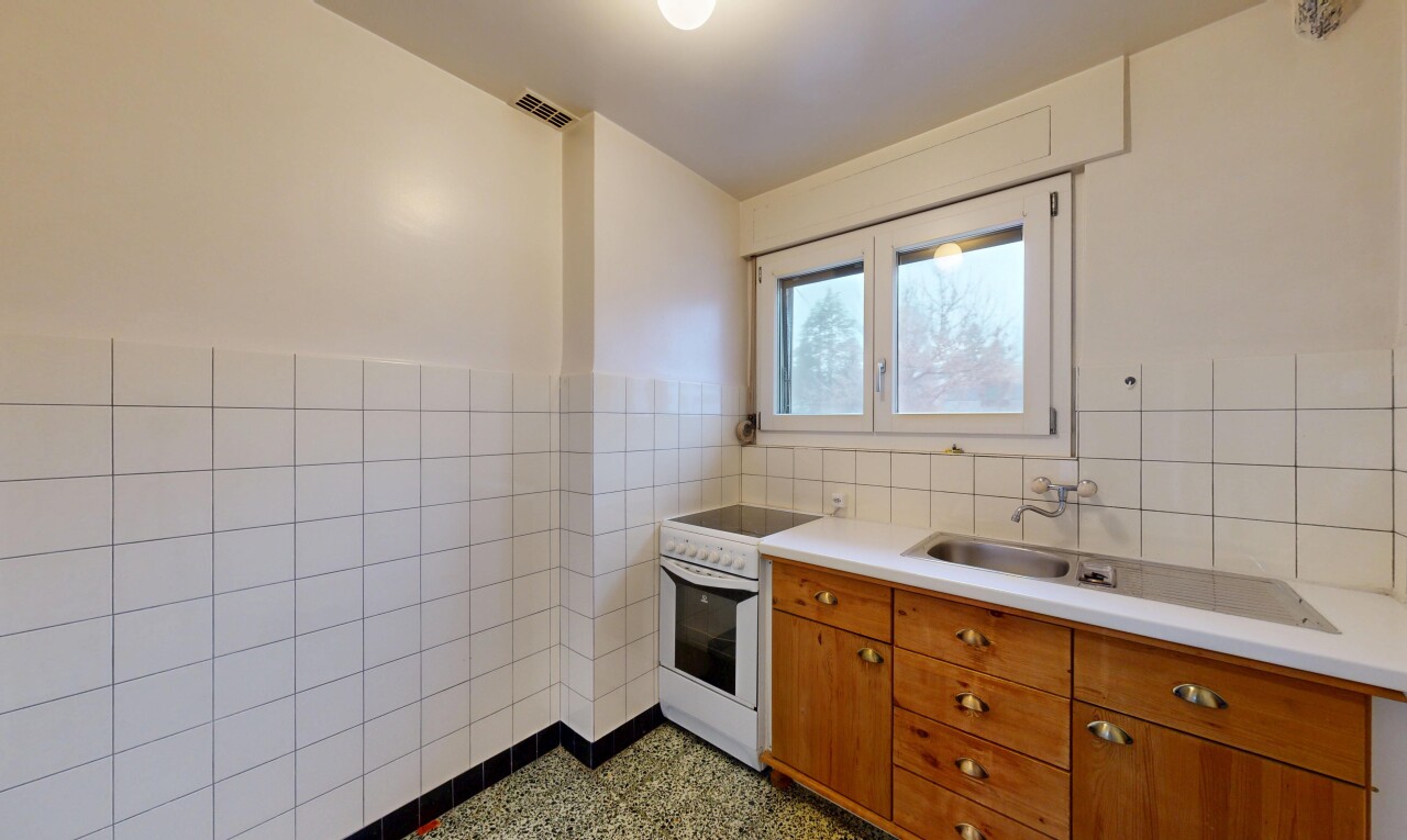 cuisine avec mur en carrelage, tile wall, cuisinière, armoires marron moyen, et plans de travail
